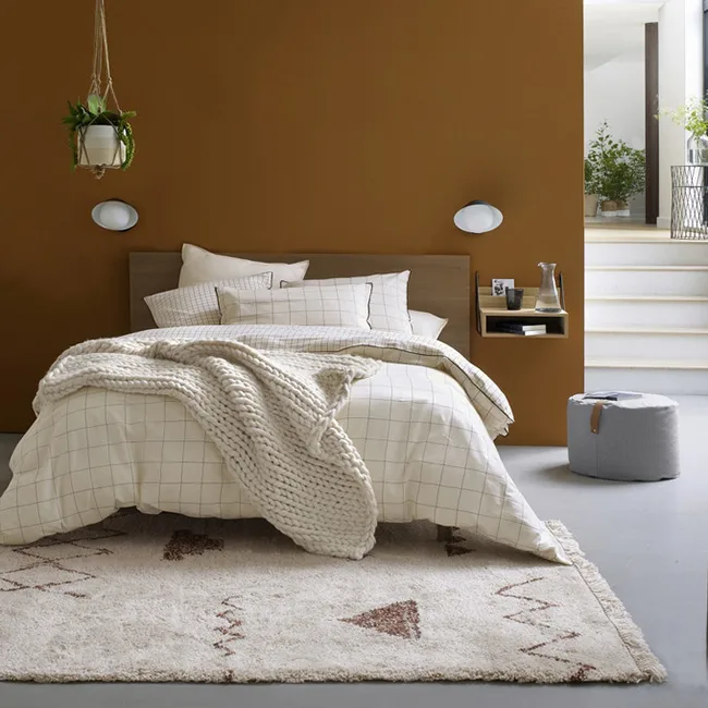 Dormitorio cálido con una mesita flotante junto a la cama